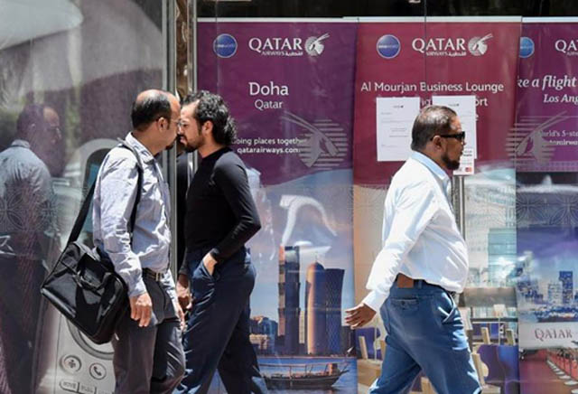 People walk past the Qatar Airways branch in the Saudi capital Riyadh, after it had suspended all flights to Saudi Arabia following a severing of relations between major Gulf states and gas-rich Qatar on June 6 (AFP photo)